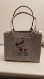 Filztasche aus hellgrauem Filz mit Fach vorne bestickt mit Mädchen auf Fahhrrad und mit Kam Snap Kunststoff-Druckknopf